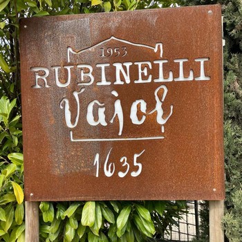 A weathered metal sign with the Rubinelli Vajol logo