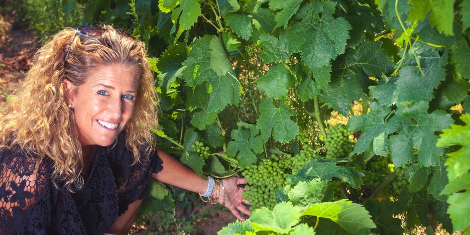 Nina Snow in Cantina Giba vineyard showing how low the fruit grows on the vines